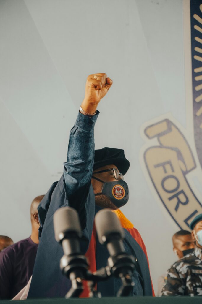 pexels-photo-10604069-10604069 A man in Nigeria raising a fist during a speech at a press conference.
